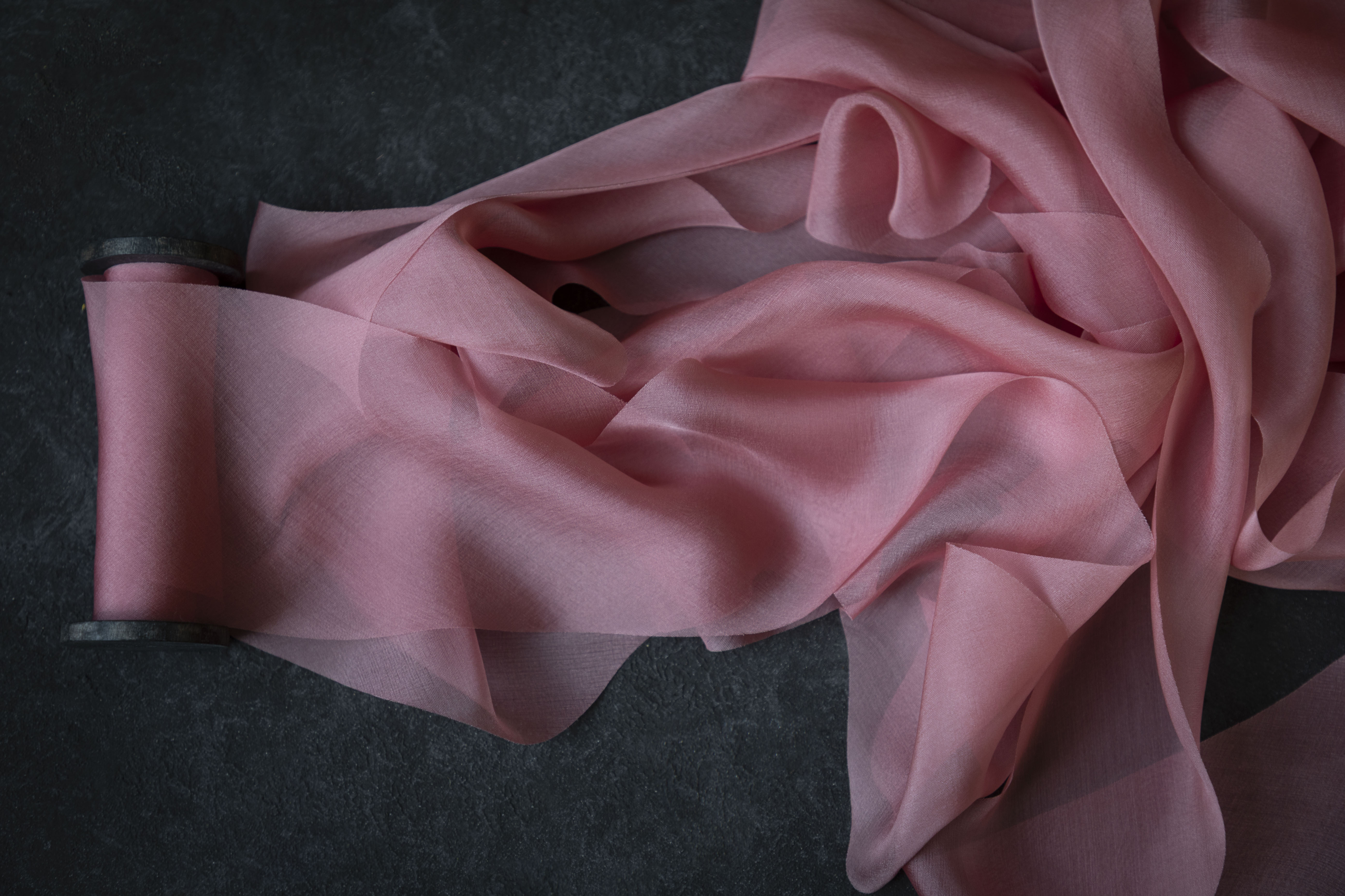 Pink silk ribbon fabric on a dark background
