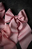 Pink satin hair bows on a dark background