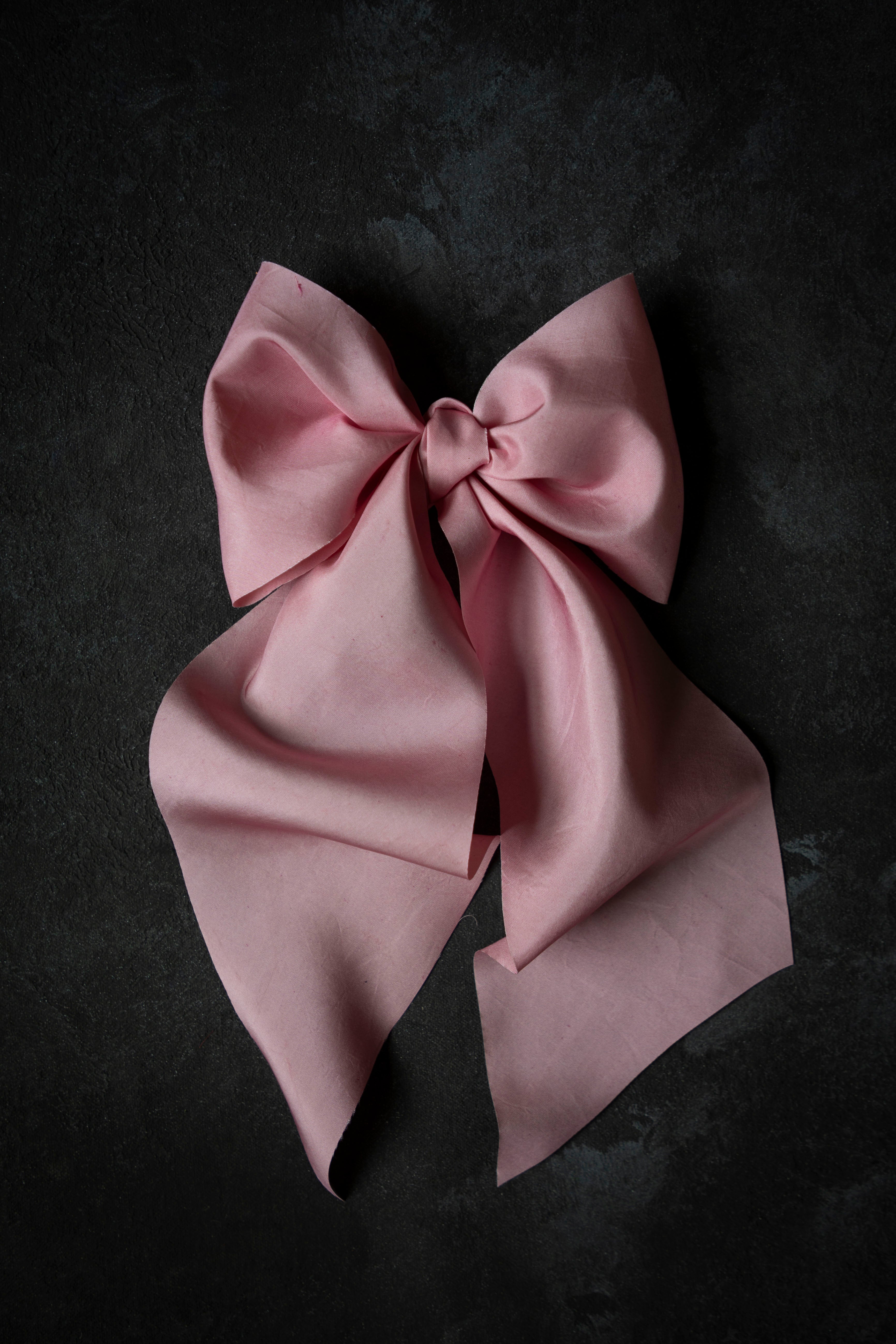 Pink satin bow on a dark background