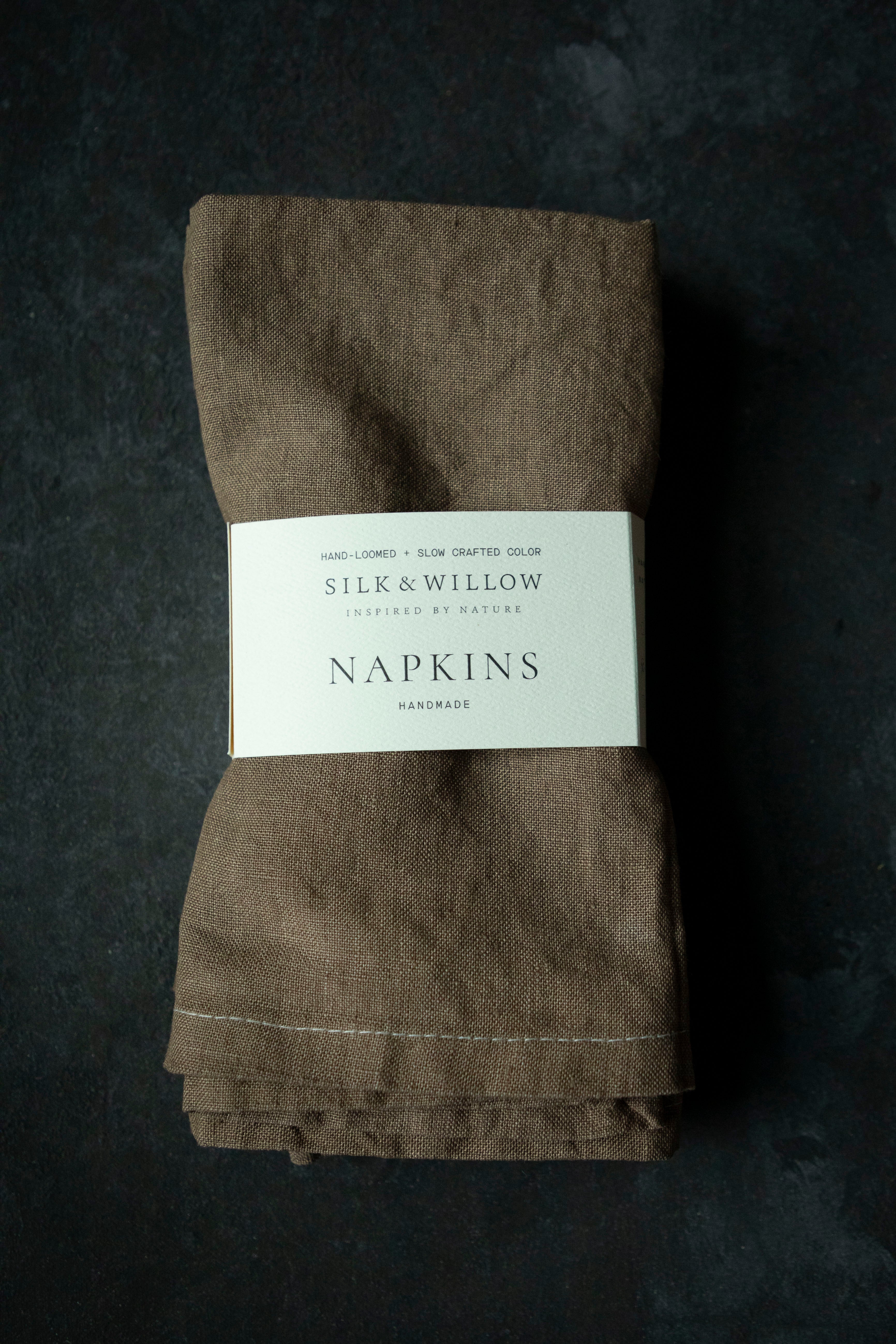 Folded brown napkins with a label on a dark background