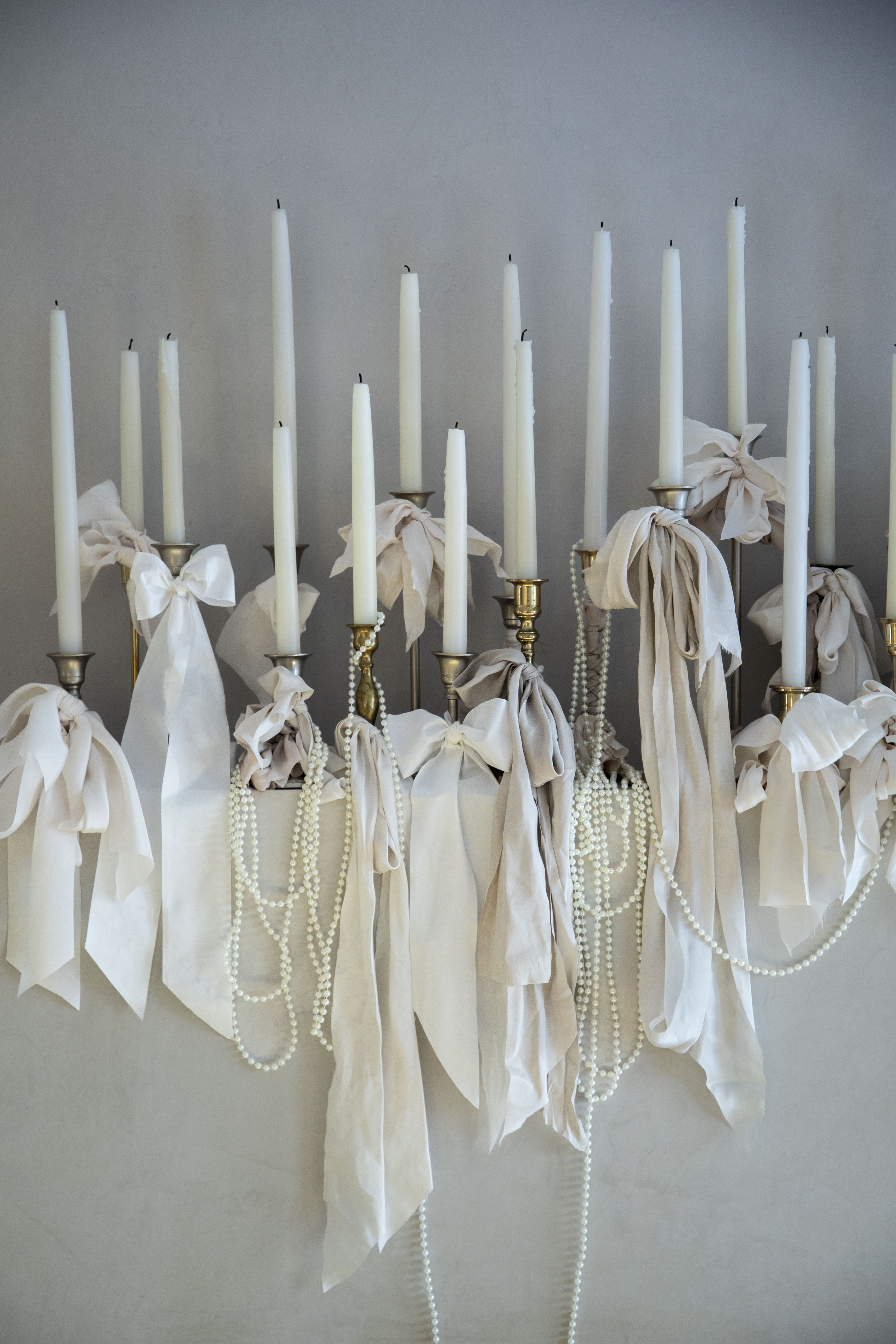 white candles with white ribbon bows wedding decor display
