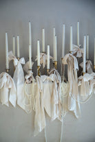 white candles with white ribbon bows wedding decor display