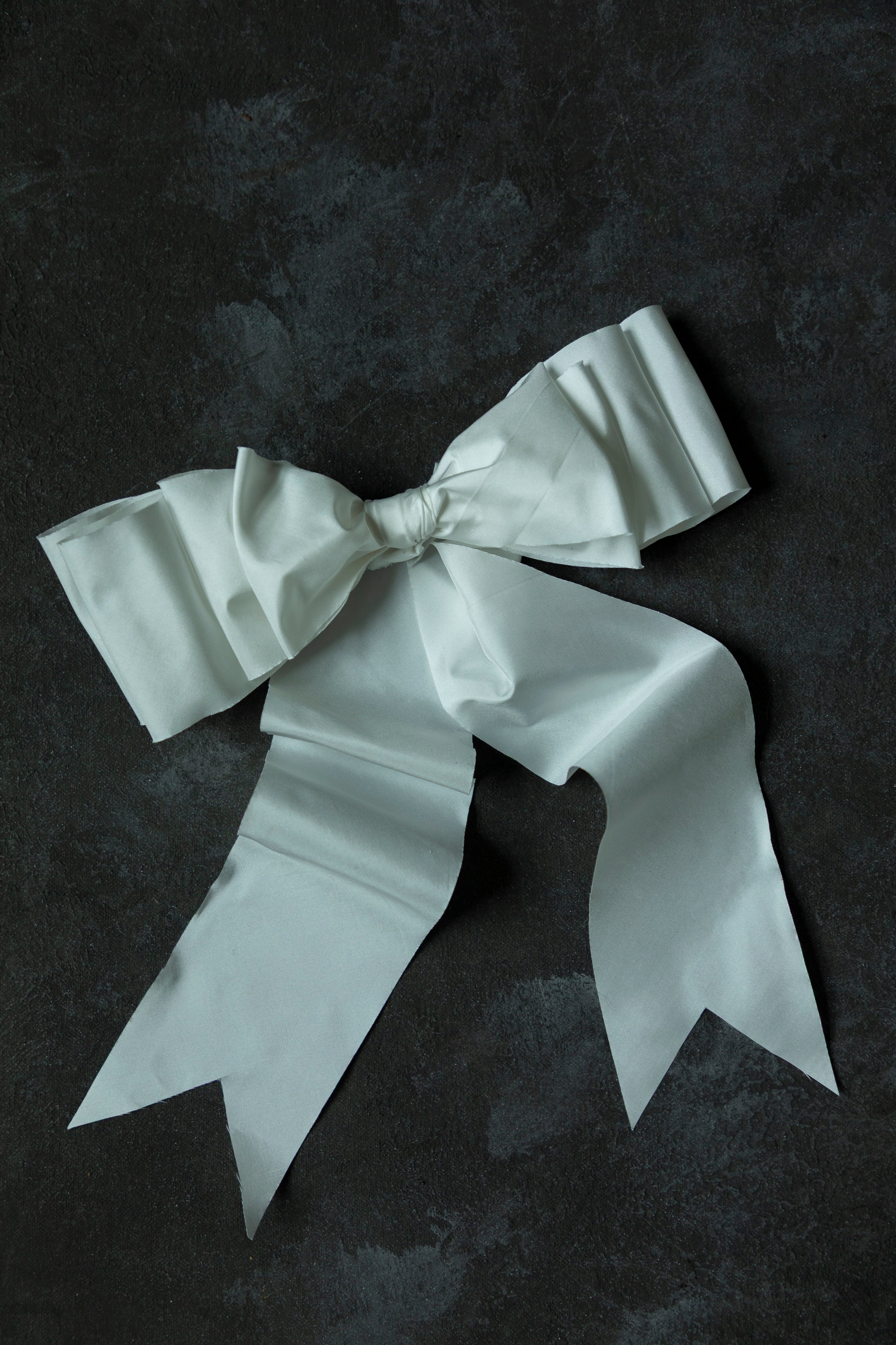 White satin bow on a dark textured background