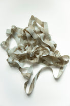 A pile of marbled silk ribbon, photographed on a plain white background.