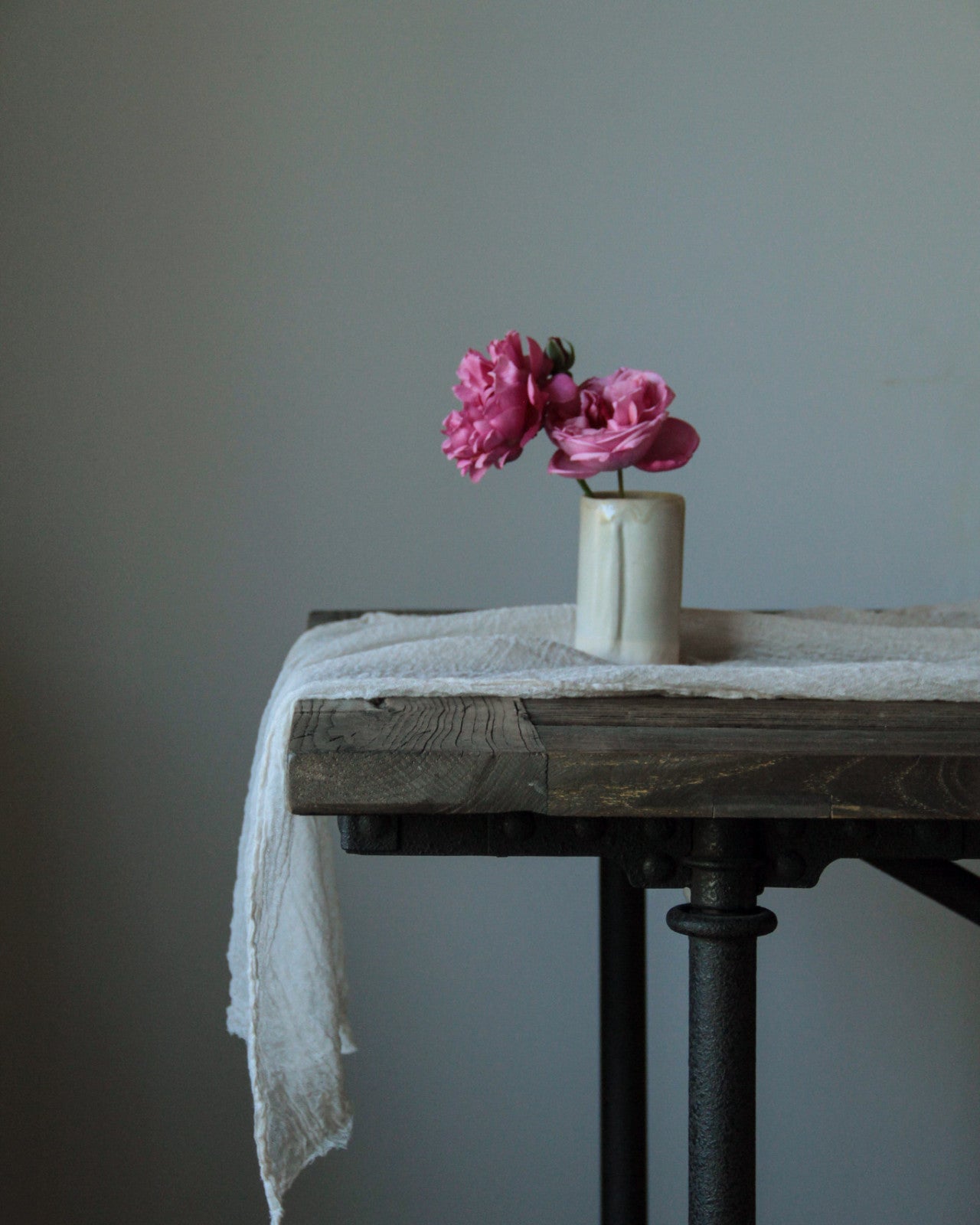 Silk and willow white table runner on a restoration hardware table and a vase with pink roses