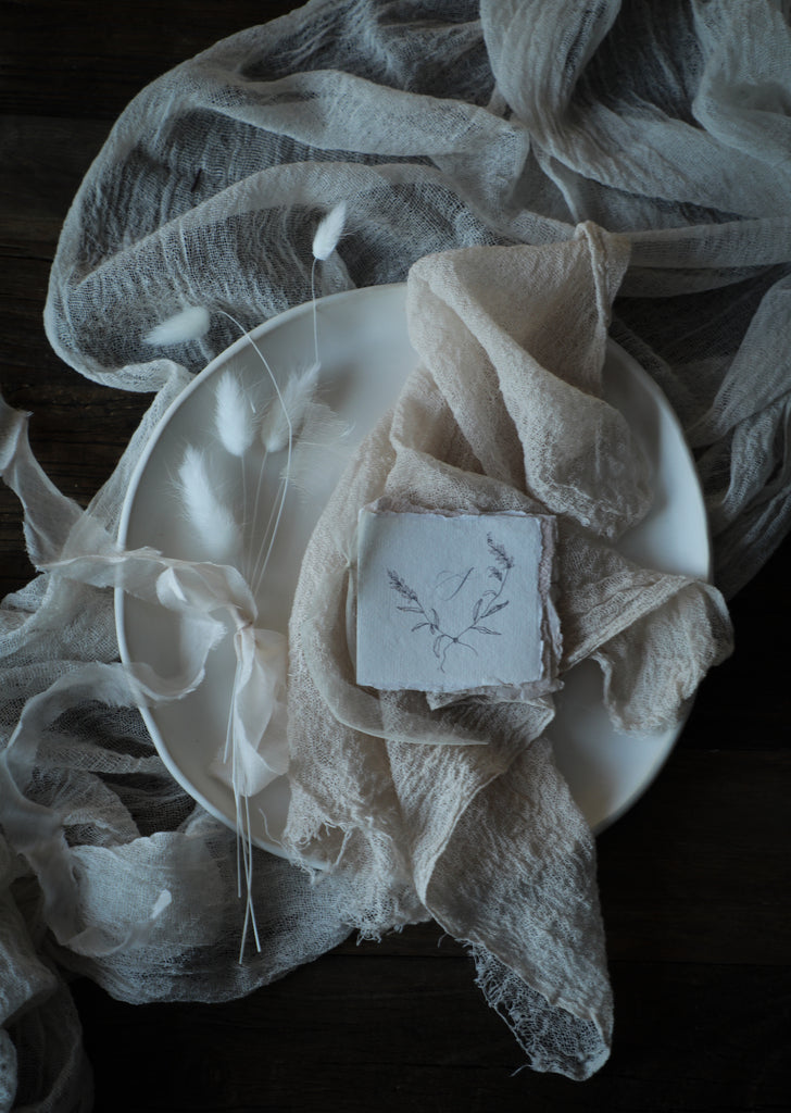 silk and willow table setting design with blush napkin, antique white table runner and white ceramic plates