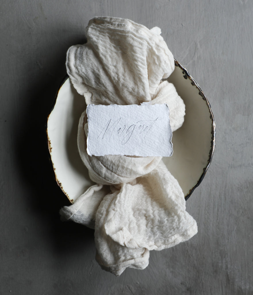 handmade paper name tag displayed on top of a white napkin