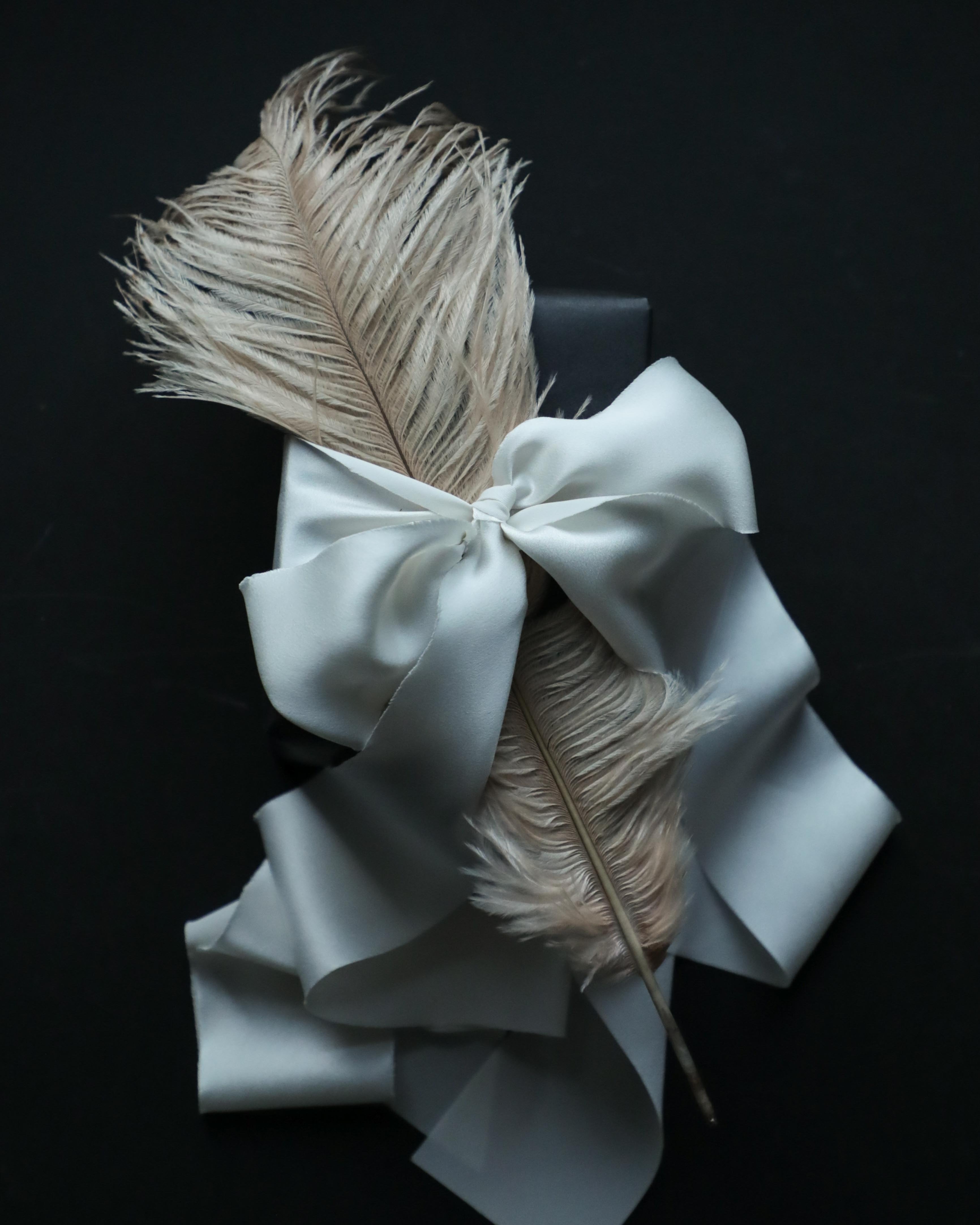Antique White satin silk ribbon with a feather. Gift wrapping inspiration
