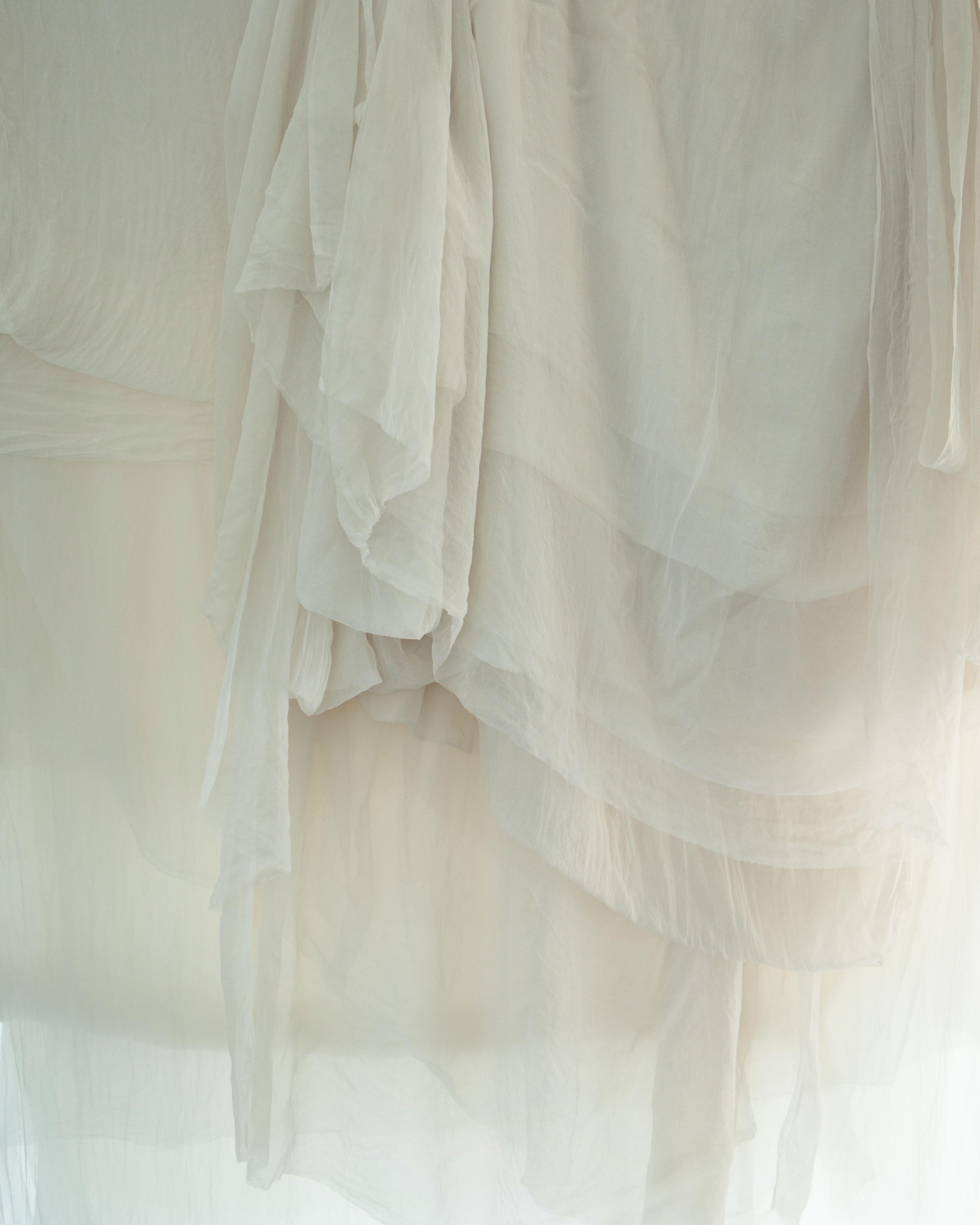 soft white sheer silk hanging in layers with light shining through