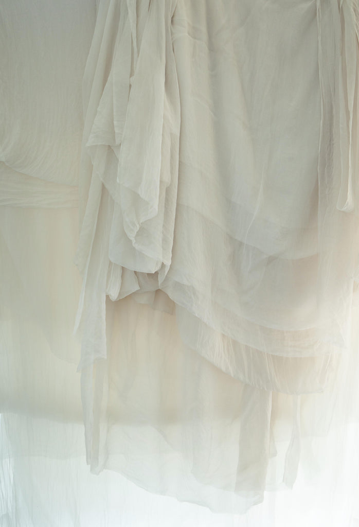 soft white sheer silk hanging in layers with light shining through