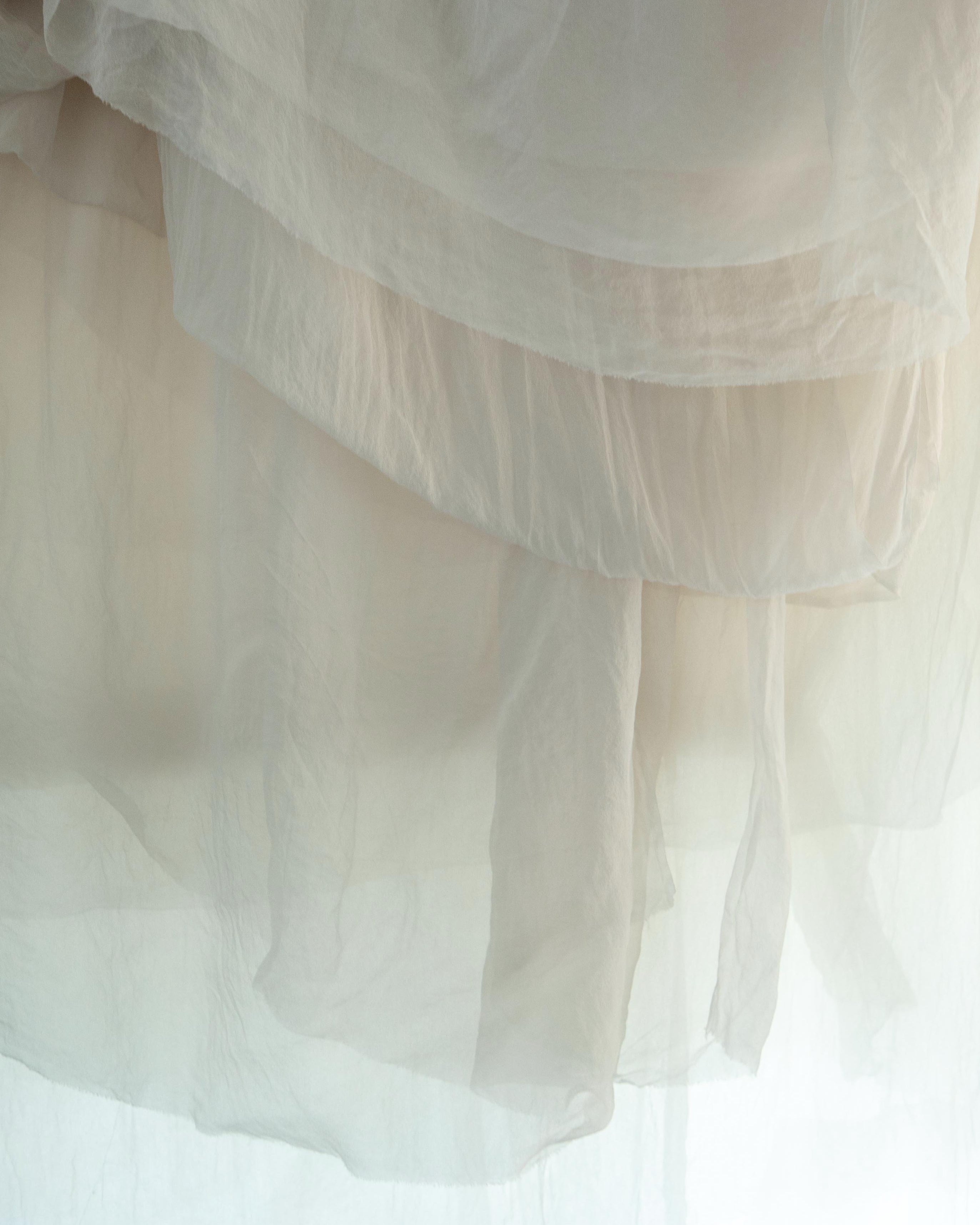 sheer silk hanging in layers with light shining through