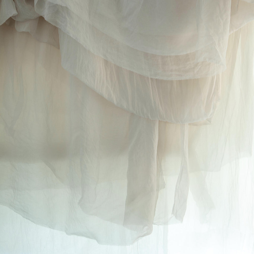 sheer silk hanging in layers with light shining through
