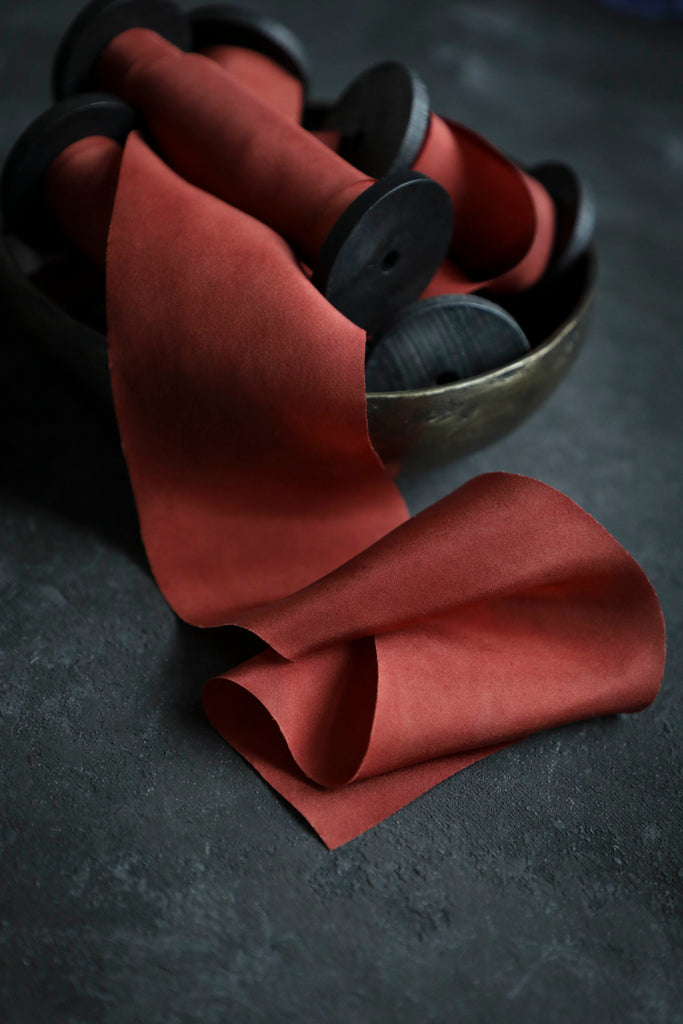 red silk ribbon on handmade wood spools