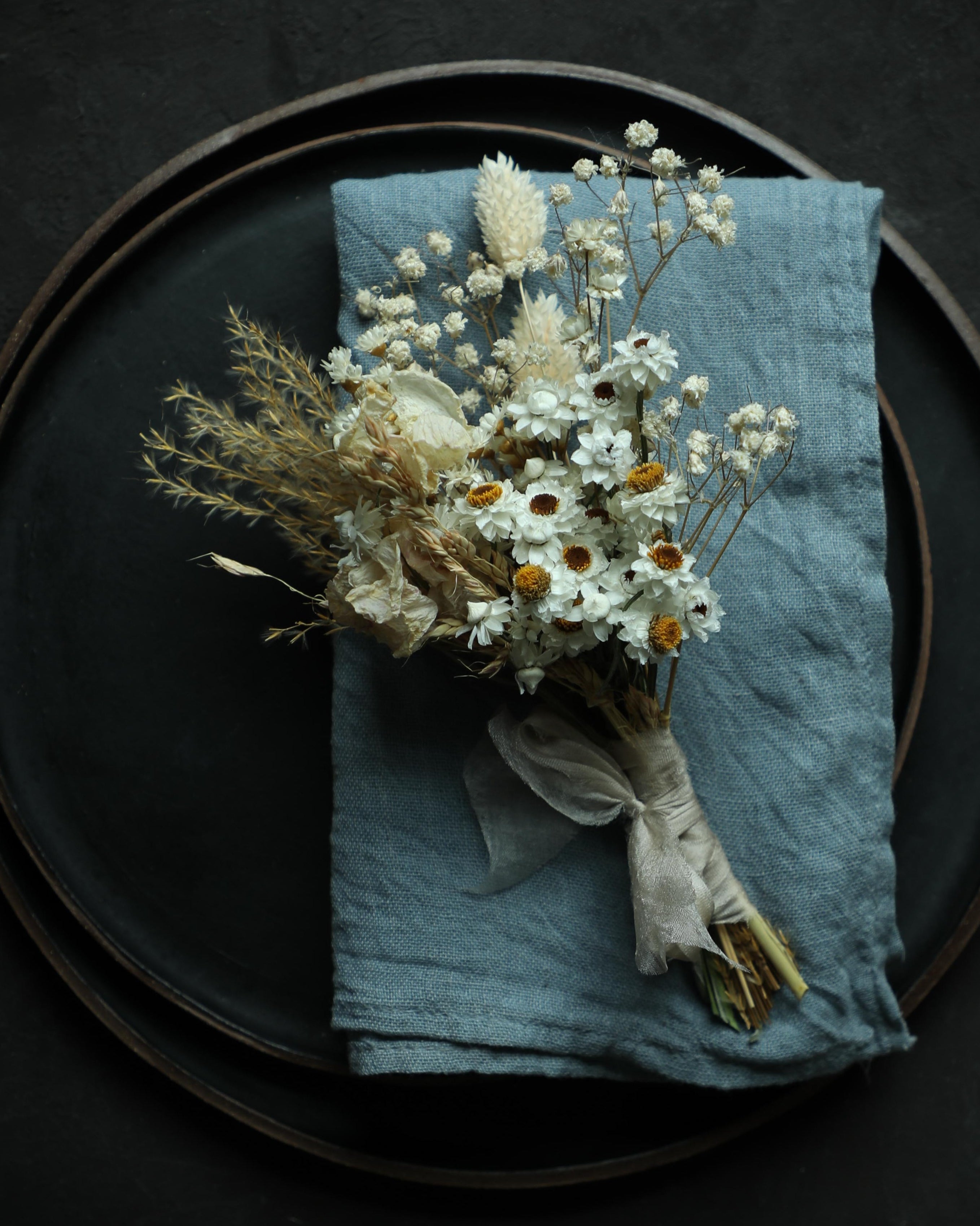 french blue napkin with dried floral arrangement