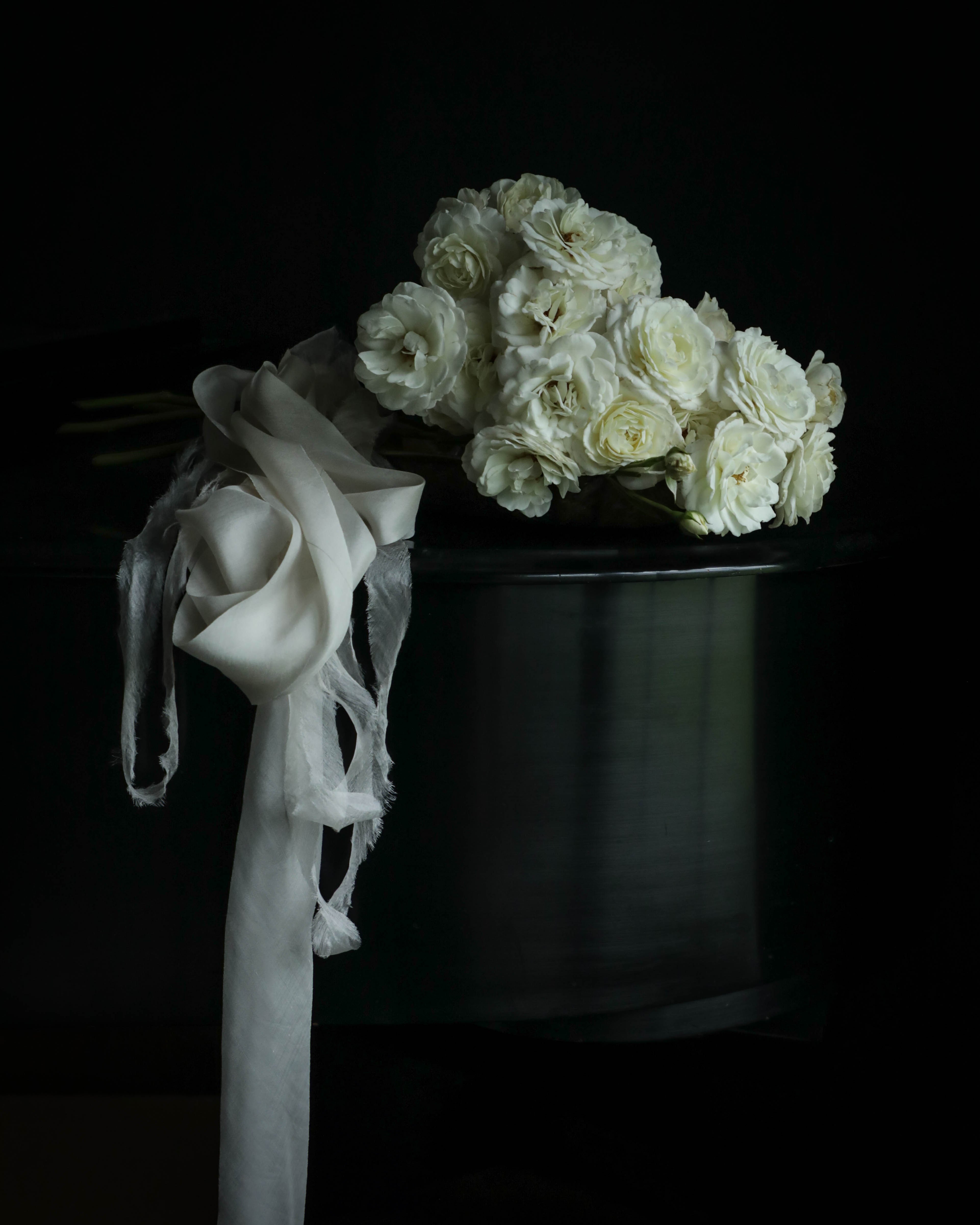 bridal bouquet with draping silk ribbon resting on a steinway paino