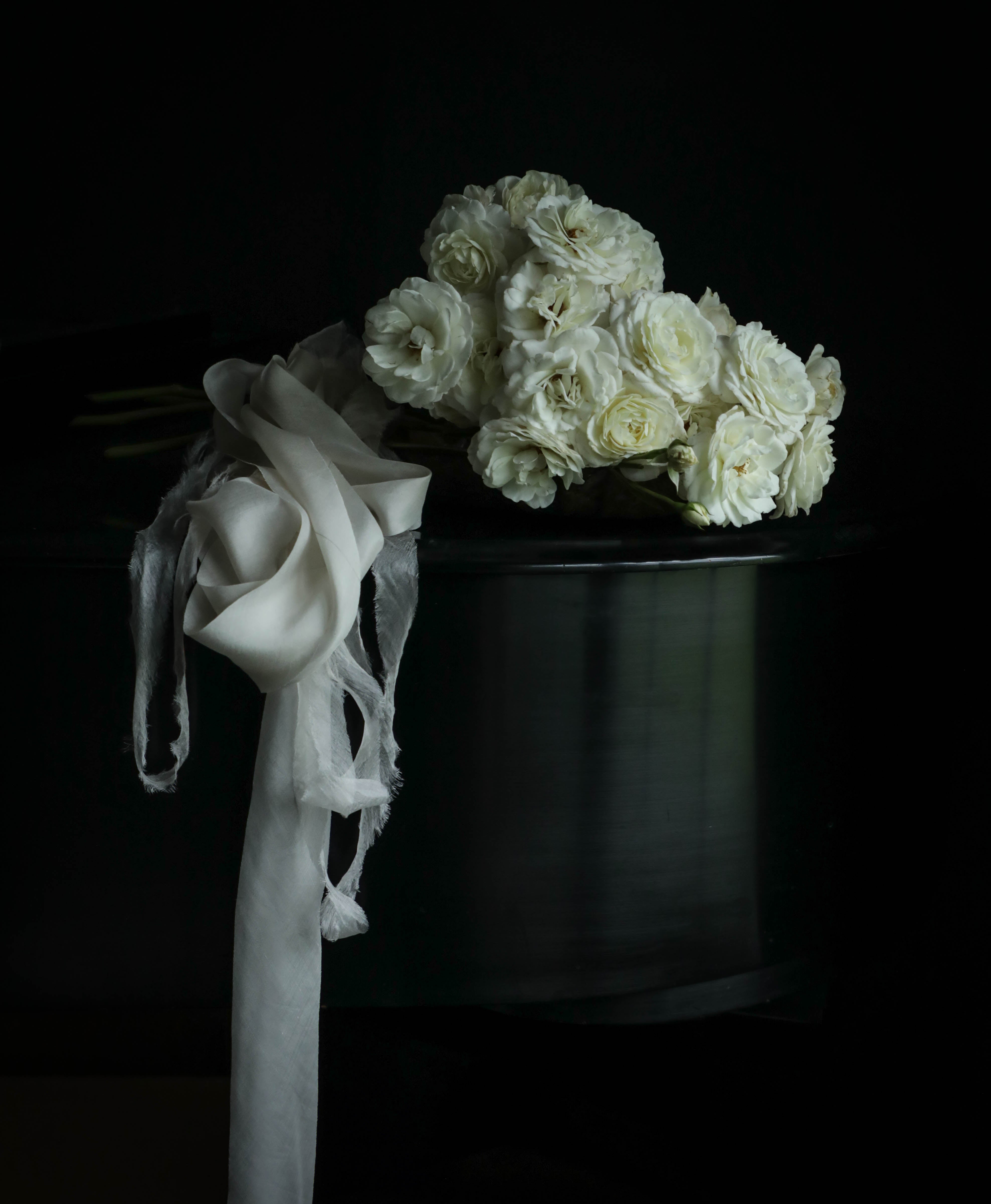 bridal bouquet with draping silk ribbon resting on a steinway paino